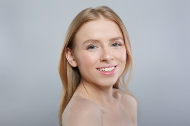 Portrait of beautiful young woman on grey background