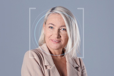 Facial recognition system. Woman with scanner frame and digital biometric grid on grey background,