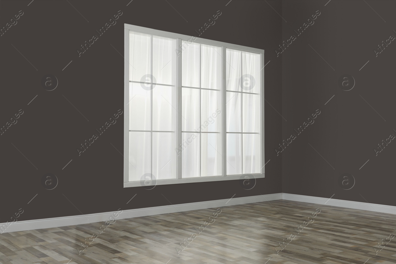 Photo of Empty room with brown walls and large window