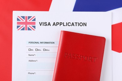 Photo of Immigration to United Kingdom. Visa application form and passport on flag, top view