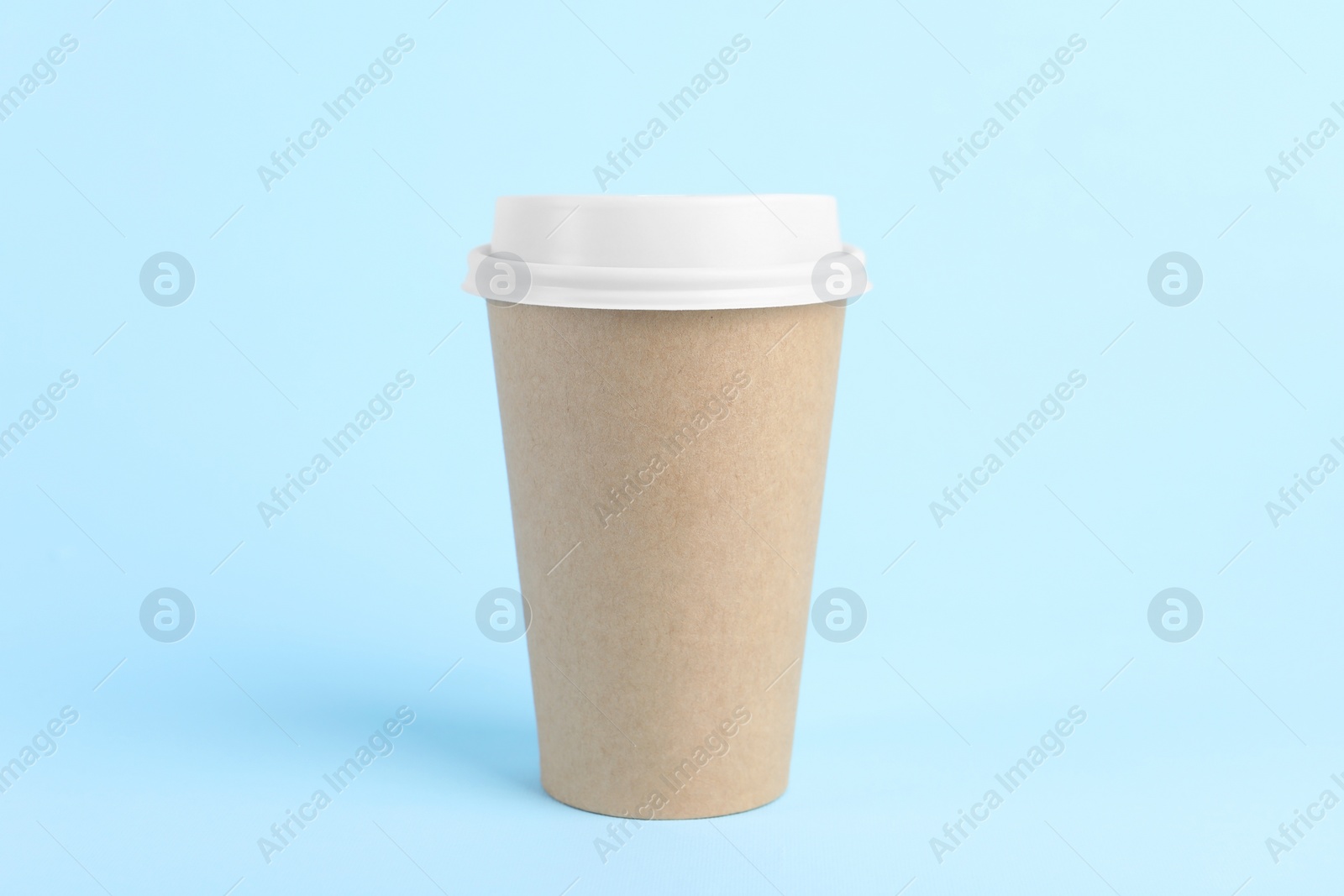 Photo of Paper cup with plastic lid on light blue background. Coffee to go