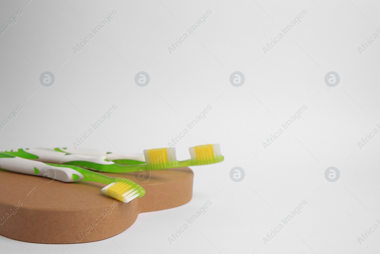 Photo of Light green toothbrushes on white background, space for text