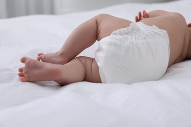 Photo of Little baby in diaper on bed, closeup