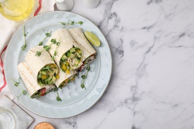 Photo of Delicious sandwich wraps with fresh vegetables and slice of lime on white marble table, flat lay. Space for text