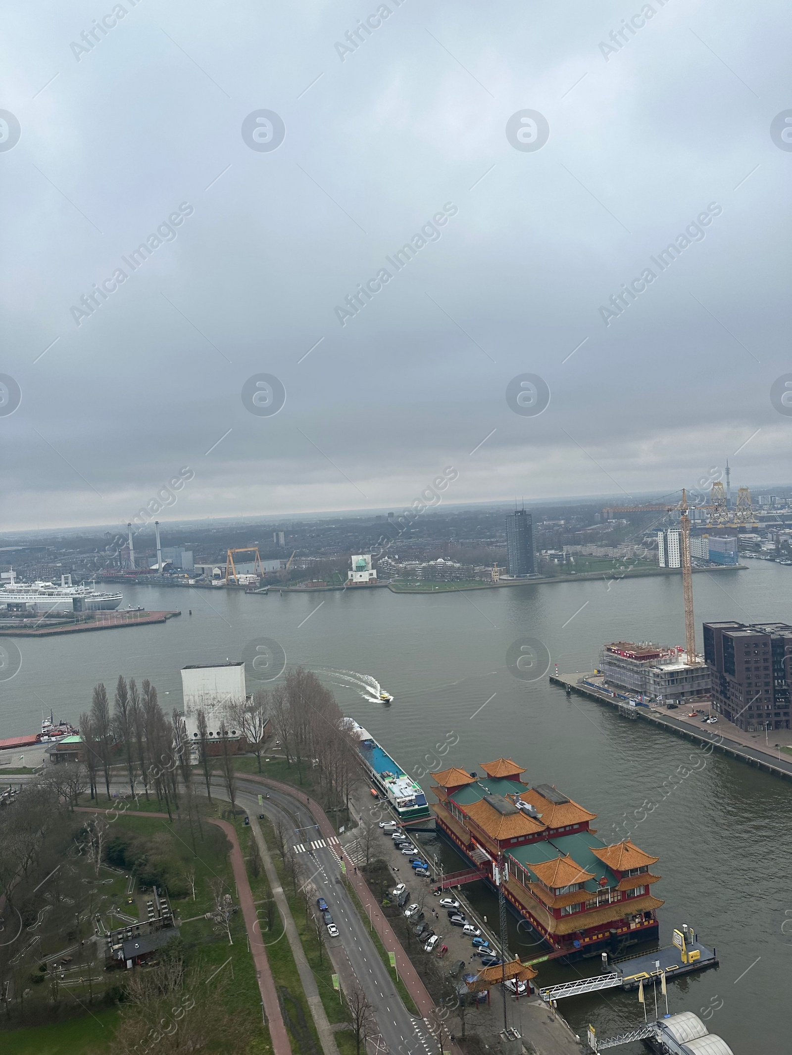 Photo of Picturesque view of city with modern buildings and harbor on cloudy day