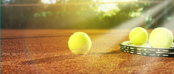 Image of Tennis balls and racket on clay court, banner design