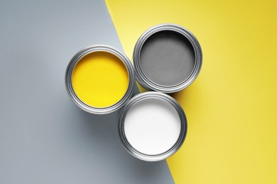 Photo of Cans with different paints on color background, flat lay