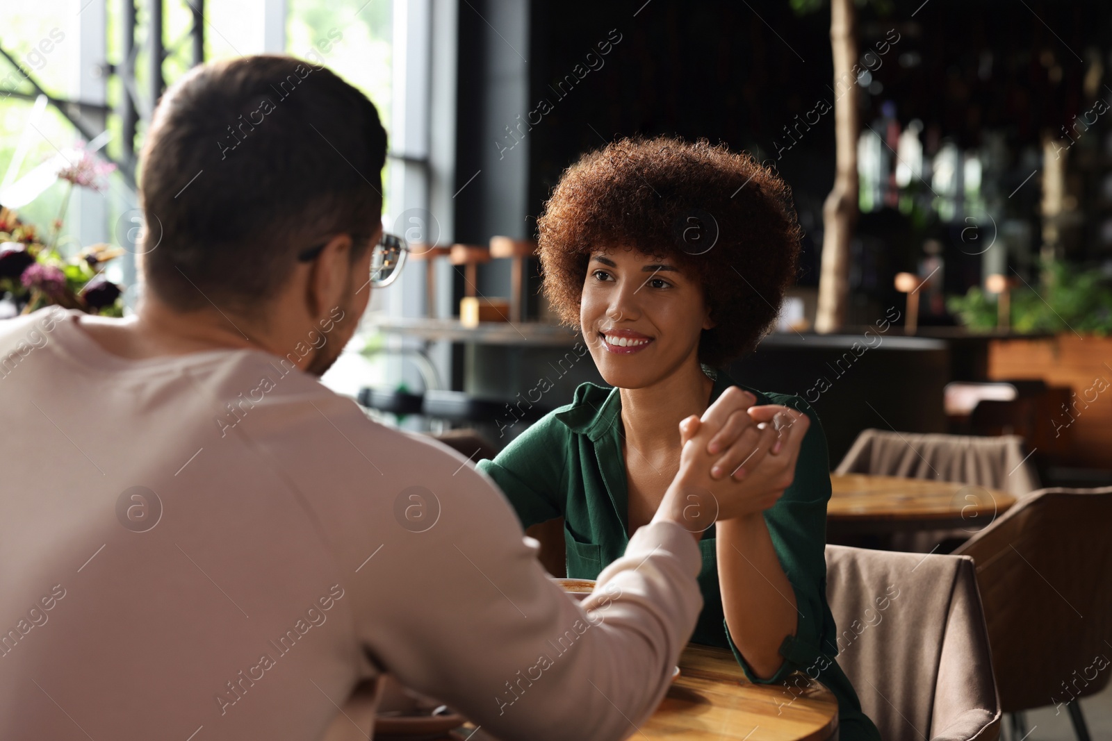 Photo of International dating. Lovely couple spending time together in cafe