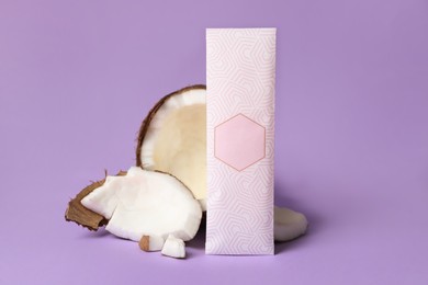 Photo of Scented sachet and pieces of coconut on violet background