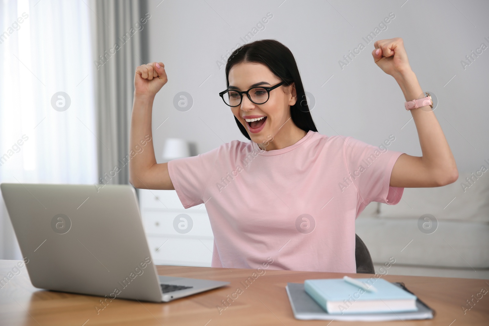 Photo of Emotional woman participating in online auction using laptop at home