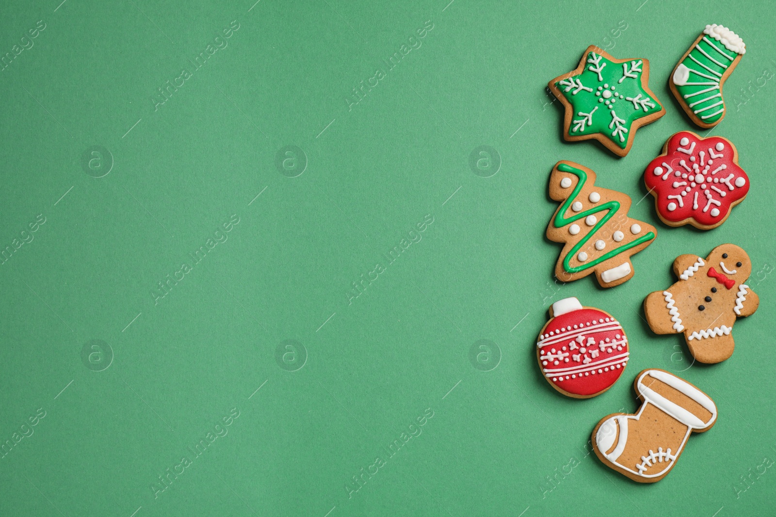 Photo of Flat lay composition with tasty homemade Christmas cookies on green background, space for text