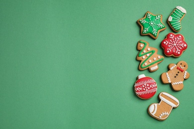 Photo of Flat lay composition with tasty homemade Christmas cookies on green background, space for text
