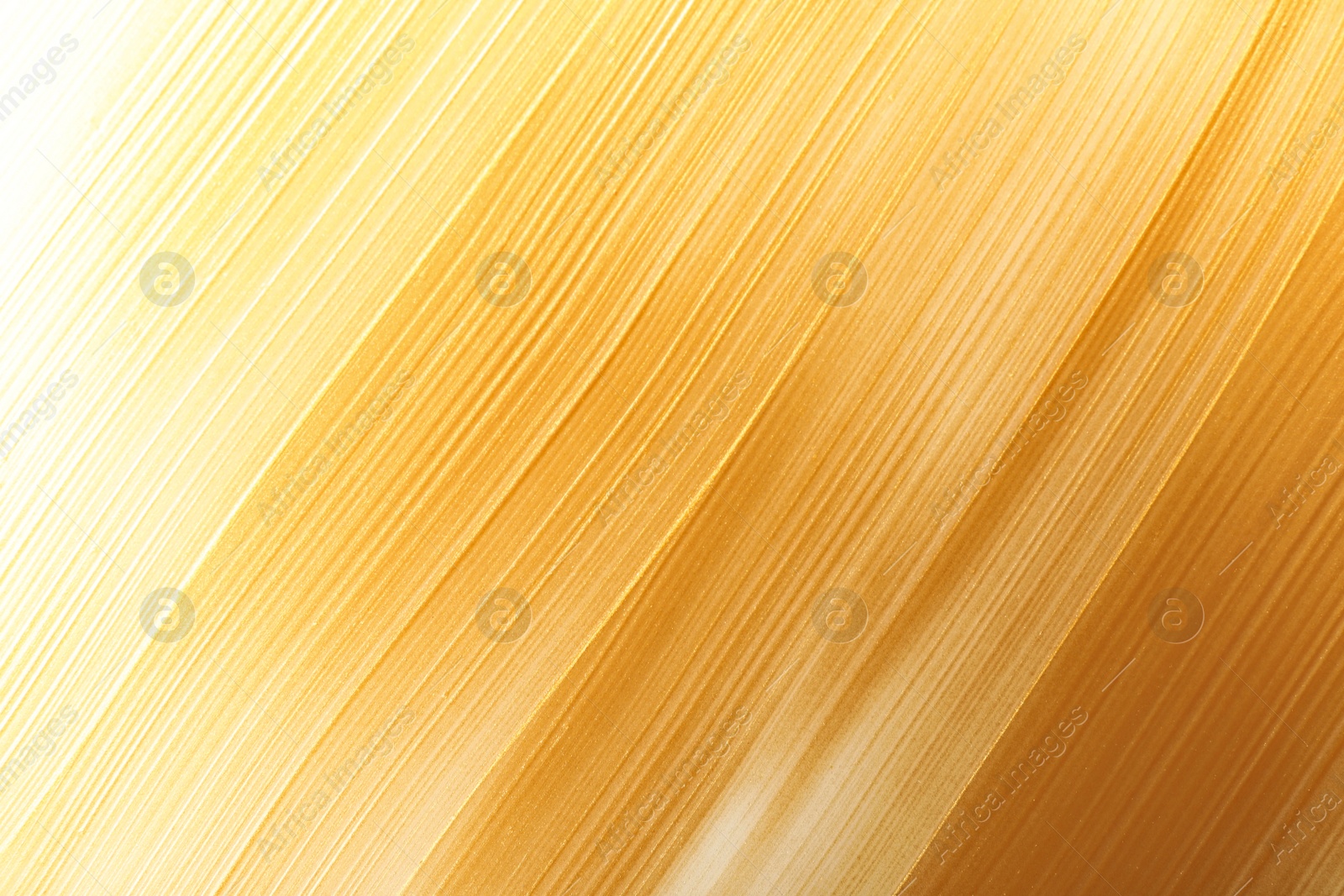 Photo of Strokes of gold paint as background, top view