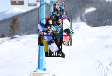 Photo of People using chairlift at mountain ski resort. Winter vacation