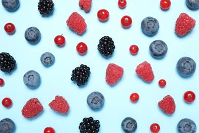 Photo of Different fresh berries on light blue background, flat lay