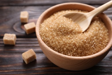 Photo of Bowl and spoon with brown sugar on table, closeup