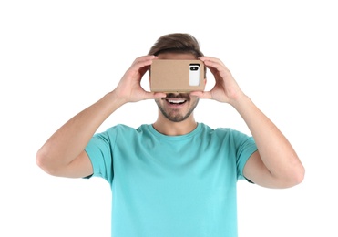 Young man using cardboard virtual reality headset, isolated on white