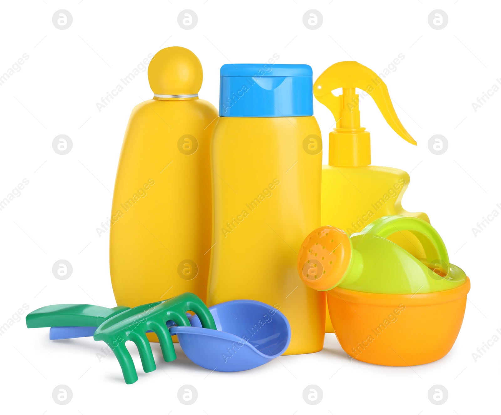 Photo of Different suntan products and plastic beach toys on white background