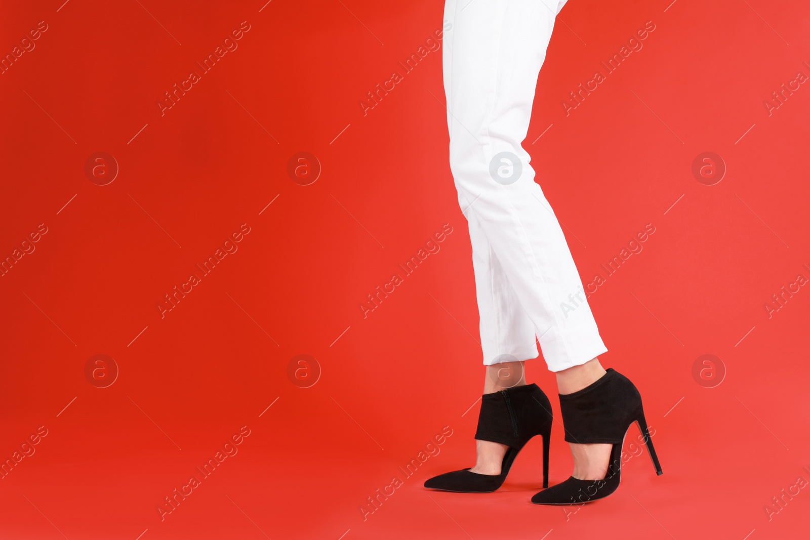 Photo of Woman in elegant shoes on red background. Space for text