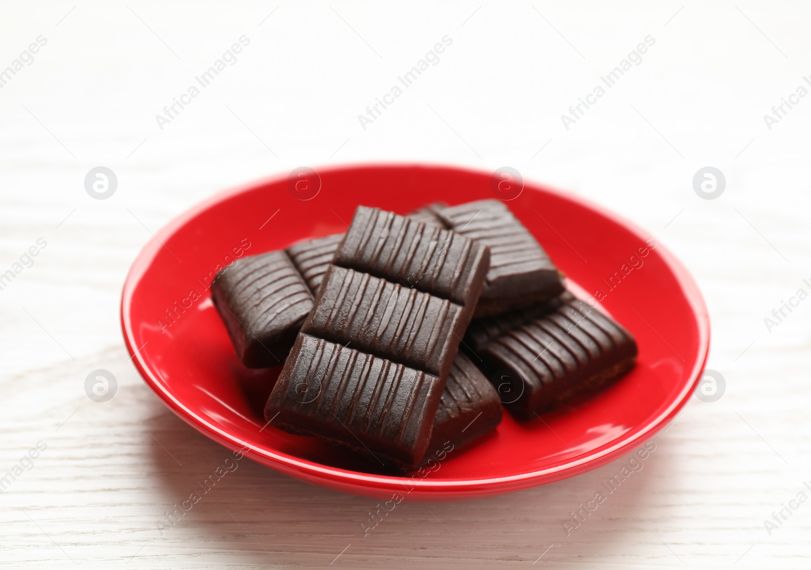 Photo of Red plate with delicious and healthy hematogen on white wooden table