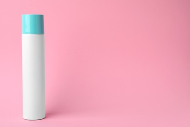 Bottle of dry shampoo on pink background. Space for text