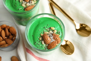 Composition with glass cups of spirulina smoothie on table