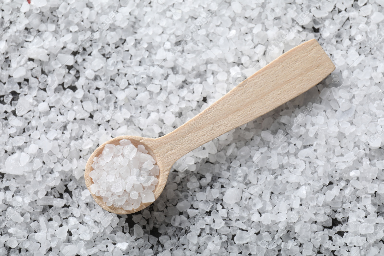 Photo of Natural salt and wooden spoon, top view