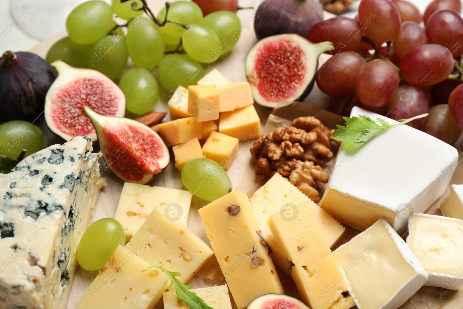 Photo of Set of different snacks with ripe figs served on board, closeup