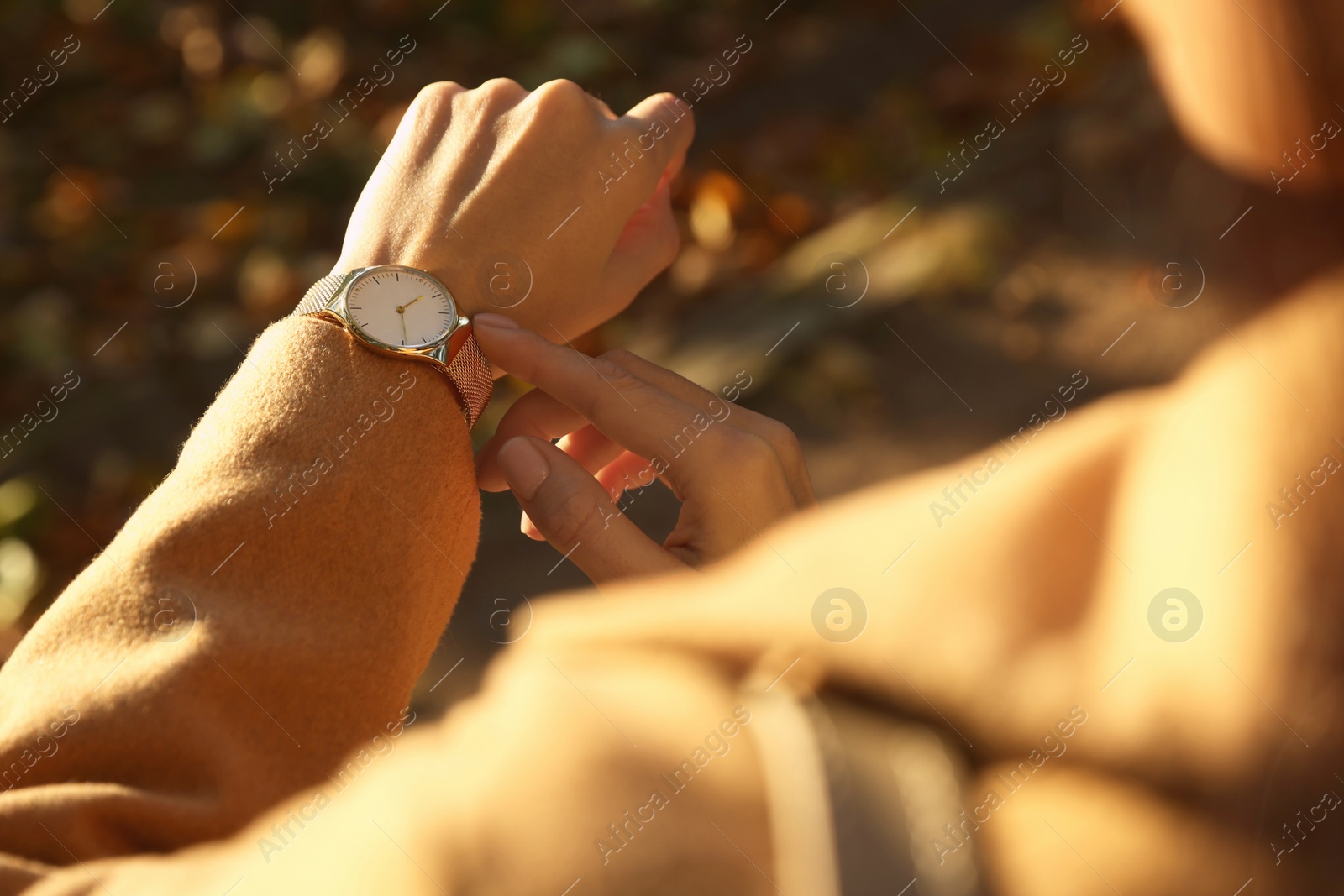 Photo of Woman checking time on watch outdoors, closeup. Being late concept