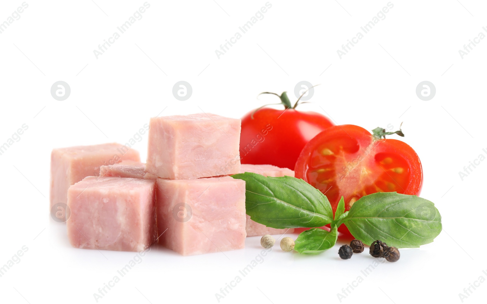 Photo of Cubes of tasty fresh ham with basil, tomatoes and pepper isolated on white