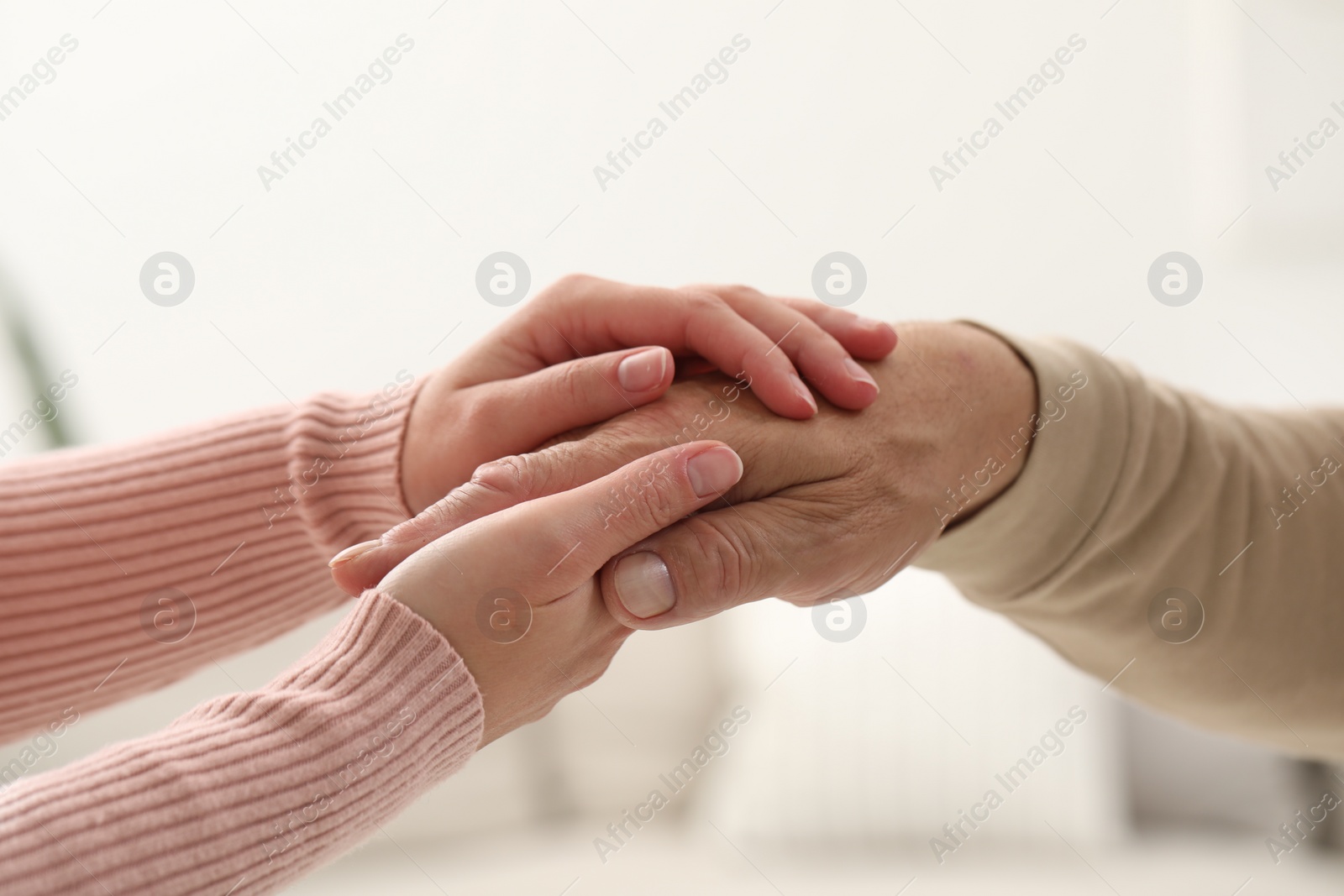 Photo of Trust and support. Woman with her dad joining hands on blurred background, closeup