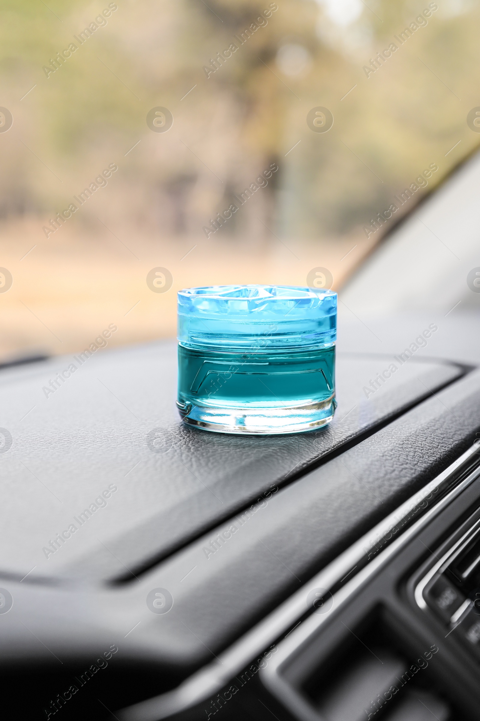 Photo of Stylish air freshener on dashboard in car