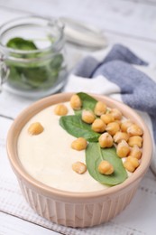 Photo of Tasty chickpea soup in bowl on white wooden table