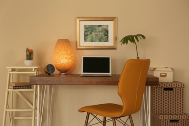 Stylish workplace with laptop on table in office