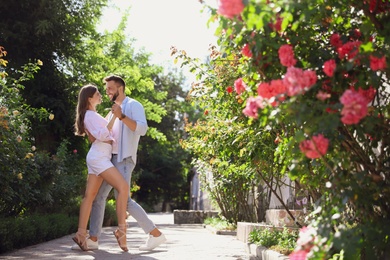 Photo of Lovely young couple dancing together in park on sunny day