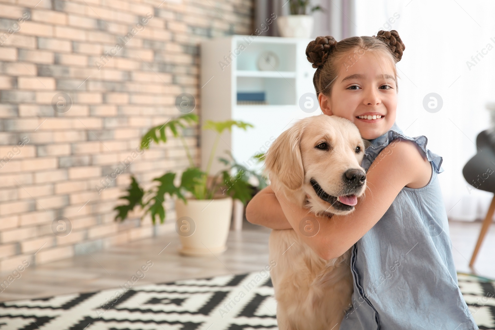 Photo of Cute little child with her pet on floor at home