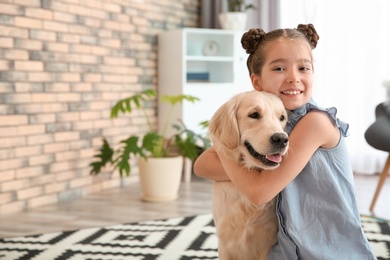 Cute little child with her pet on floor at home