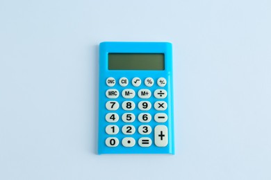 Photo of Light blue calculator on white background, top view