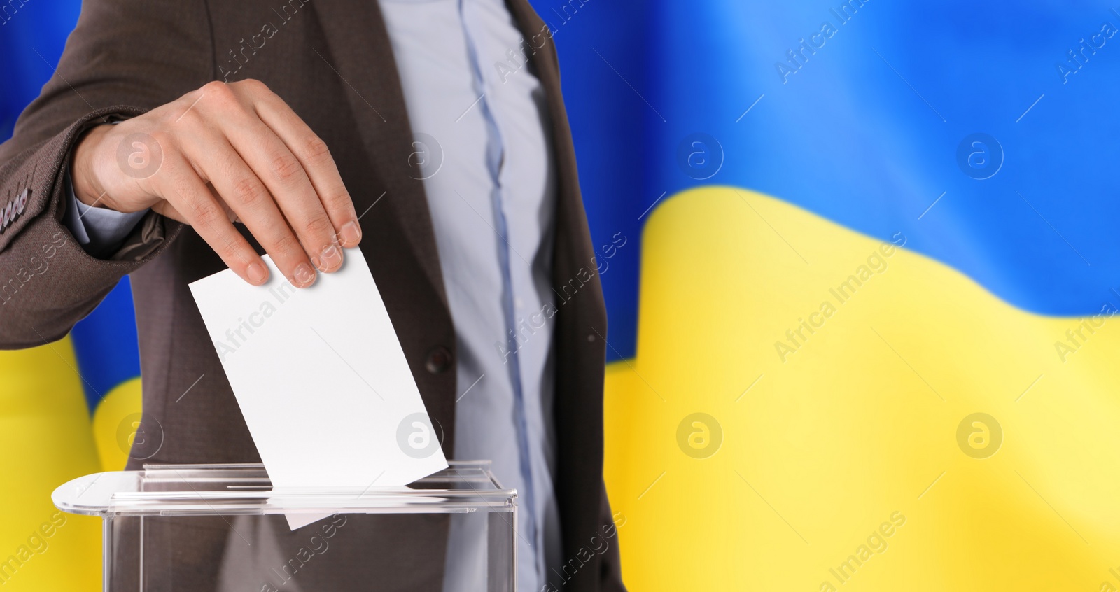 Image of Man putting his vote into ballot box against national flag of Ukraine, closeup. Banner design with space for text