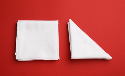 Photo of Stylish white handkerchiefs on red background, flat lay
