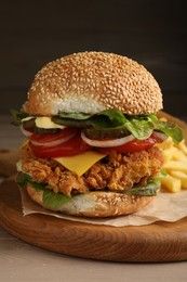 Photo of Delicious burger with crispy chicken patty on wooden table, closeup