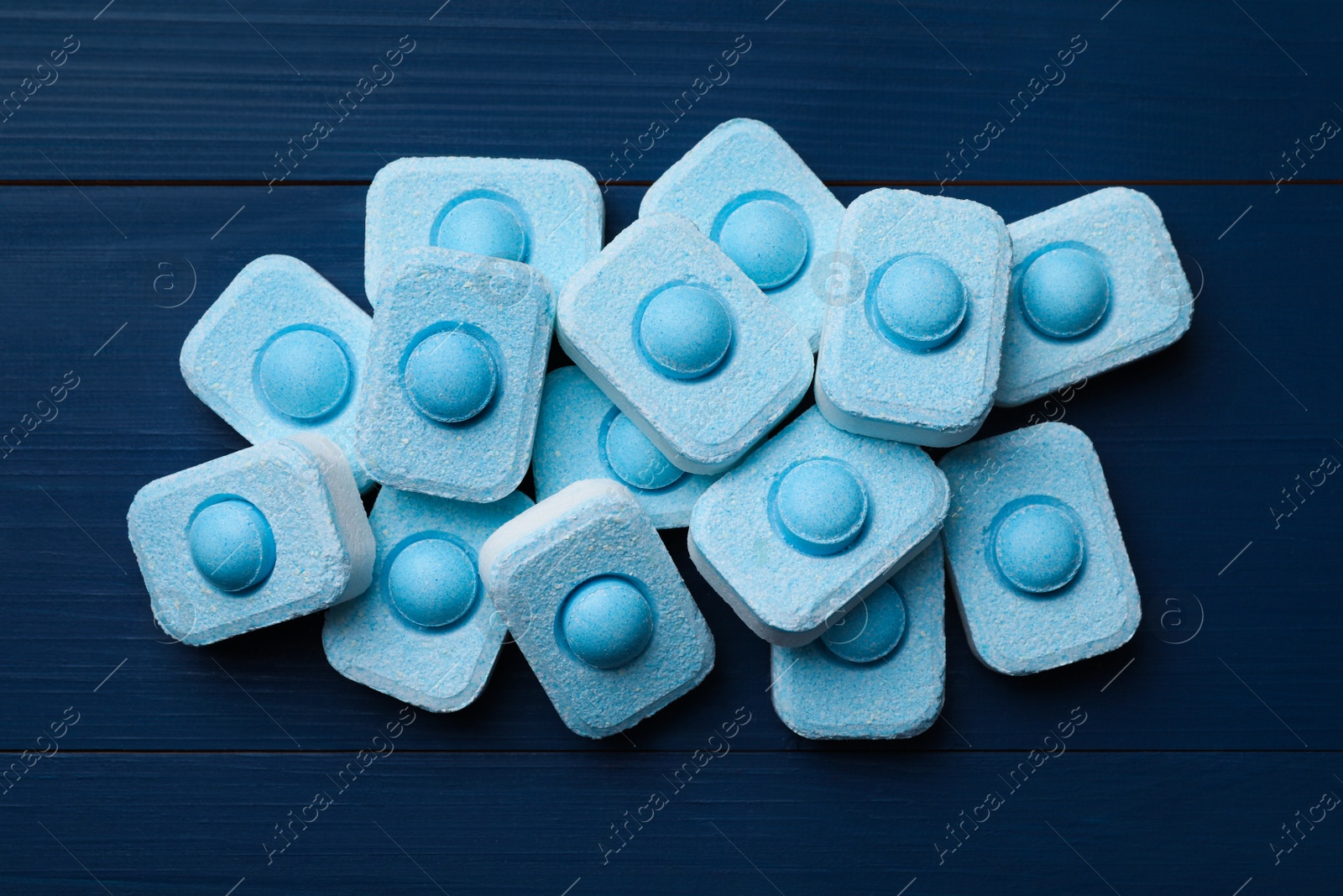 Photo of Water softener tablets on blue wooden table, flat lay