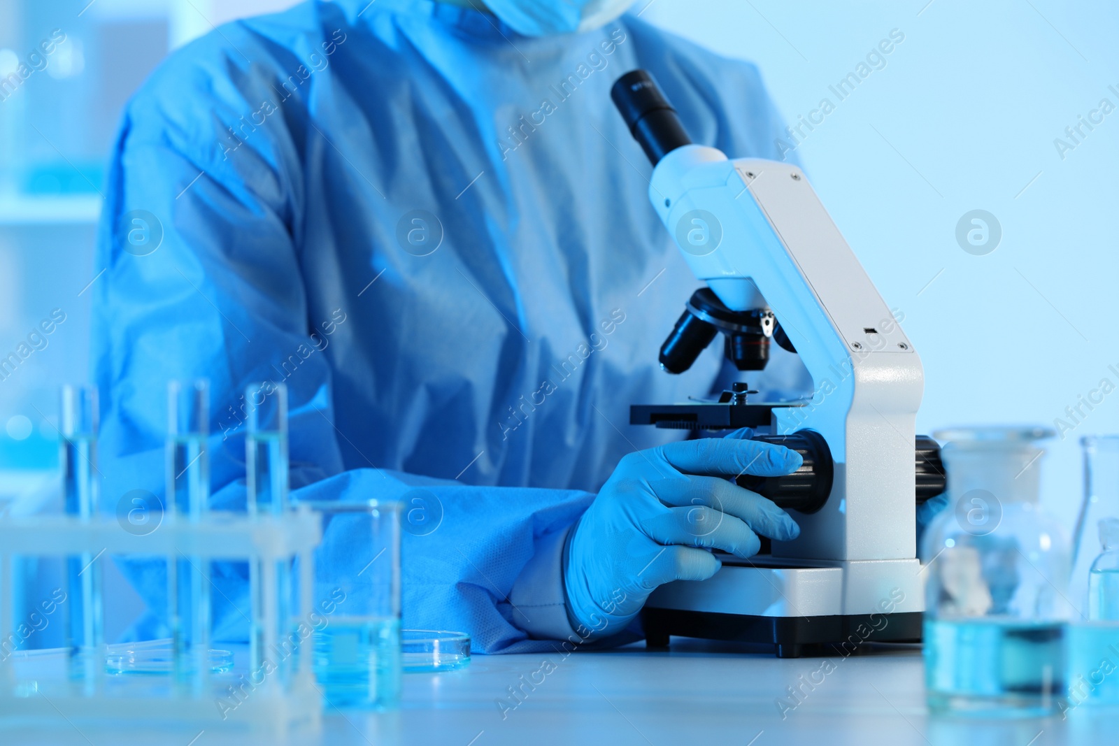 Photo of Scientist working with microscope in laboratory, closeup. Medical research