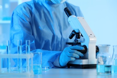 Photo of Scientist working with microscope in laboratory, closeup. Medical research