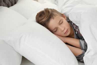 Photo of Cute tired boy sleeping in comfortable bed