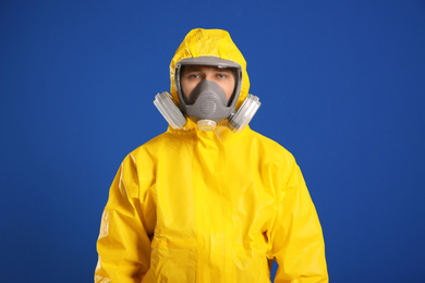 Photo of Man wearing chemical protective suit on blue background. Virus research