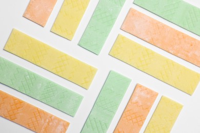 Photo of Sticks of tasty bubble gums on white background, flat lay