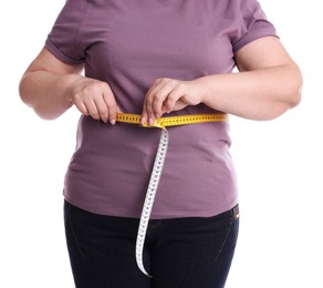 Photo of Overweight woman measuring waist with tape on white background, closeup