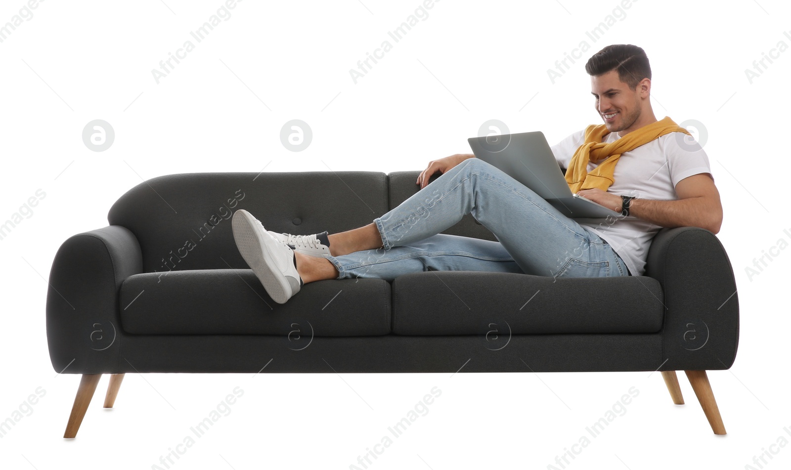 Photo of Man with laptop on comfortable grey sofa against white background