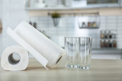 Rolls of paper towels and glasses on table in kitchen